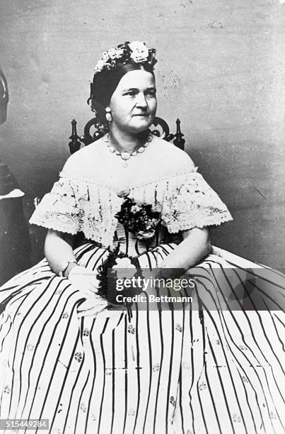 Portrait of Mary Todd Lincoln in formal dress hodling a bouquet of flowers. Photo by Mathew Brady. Undated photo.