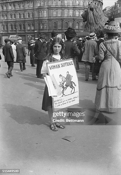 Suffragists in England. Young girl as placard bearer during suffragist demonstration. Placard depicts political cartoon with the caption: "Mrs Bull:...