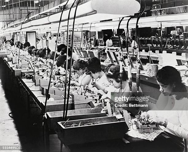 Hato Rey, Puerto Rico-ORIGINAL CAPTION READS: General view shows the assembly line of women where electronic timers are progressively wired and...