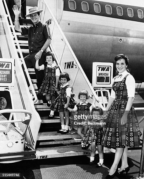 New York, NY- With his family in tow, singer Pat Boone bids goodbye to New York, as he boards a Trans World Airlines jet at Idlewild Airport....