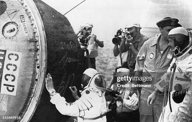 Baikonur, U.S.S.R.- Photographers capture the moment for posterity as Soviet cosmonaut Valery Kubasov autographs the Soyuz-19 space capsule following...