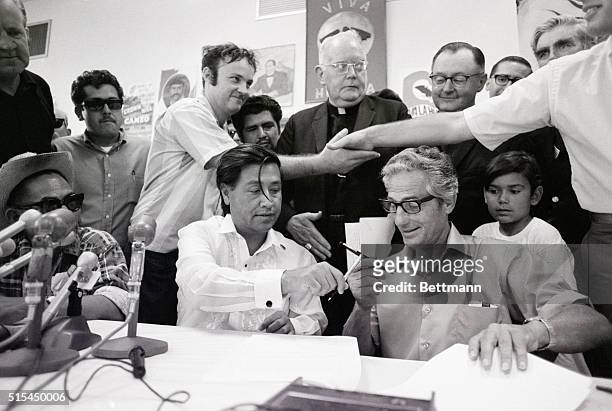 Delano, California. The hands of United Farm Workers attorney, Jerry S. Cohen , and John Guimarra, jr. Clasp in the background, as Cesar Chavez of...