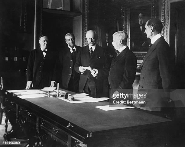 United States Secretary of State Robert Lansing hands Danish Minister Brun a draft for $25 000, in purchase of the Danish West Indies . Pictured are:...