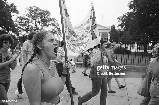 Group of women carry a banner past the White House, calling for the passage of the Equal Rights Amendment.