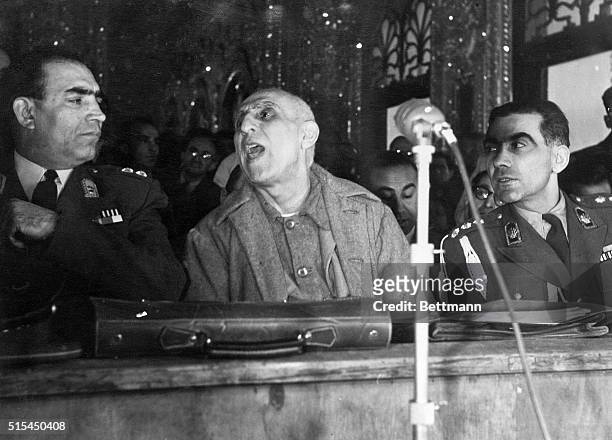 Teheran, Iran- Flanked by two guards, former Iranian Premier Mohammed Mossadegh is shown holding the floor at the opening session of his trial in...