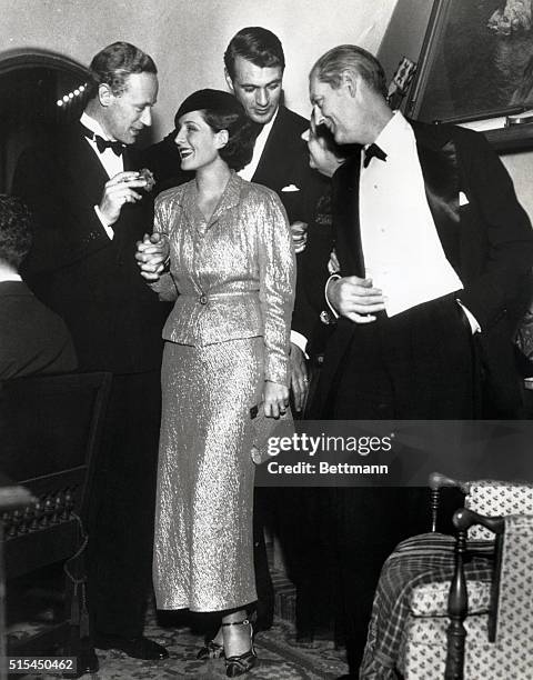 Hollywood, CA-: Leslie Howard, Norma Shearer, Gary Cooper and Lionel Barrymore are seen here during the Christmas Eve party given by Cooper at his...