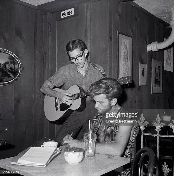 New York, NY- Don Stewart plays guitar as Dick Woods writes poetry, in the Gaslight coffee house in Greenwich Village. At places like the Gaslight,...