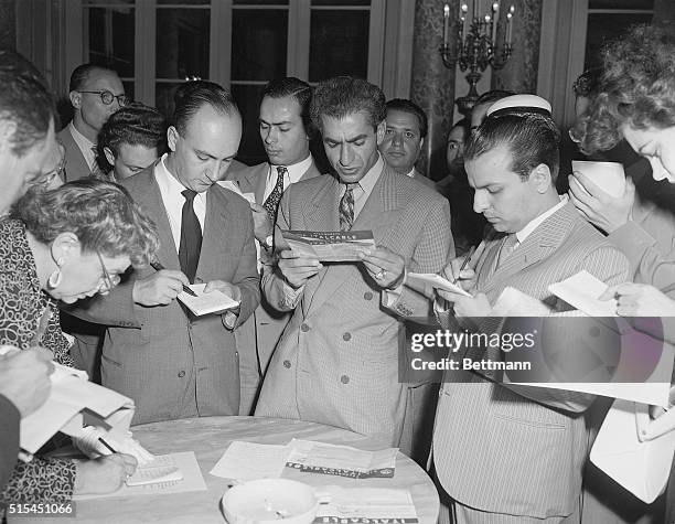 Rome, Italy- Shah Mohammed Reza Pahlavi is flanked by reporters, as he reads a telegram urging him to return to Tehran. After five days in exile in...