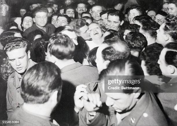 Paris, France- Laughing, disheveled Marlene Dietrich is mobbed by GI's after her act at the opening of the Paris Stage Door Canteen, sponsored by the...