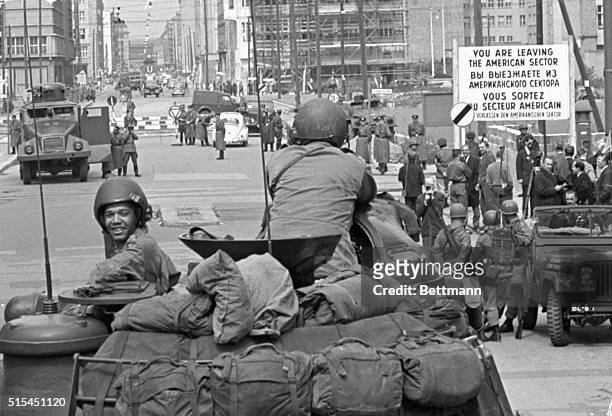 Berlin, Germany- A United States Army tank crew watches an East German water cannon facing them across the border at the Friedrichstrasse border...