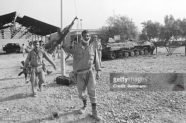 Shalamja, Iraqui-occupied Iran- Iraqi soldiers at this Iranian border checkpoint wave and carry AK47 automatic weapons, as they walk past a destroyed...