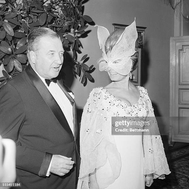 New York, NY-: Adding to the glitter and dazzle at author Truman Capote's masked party are Mr. And Mrs. Henry Ford II.