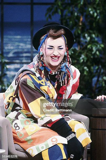 Boy George smiles as Joan Rivers pats her guest's hand during The Joan Rivers Show.