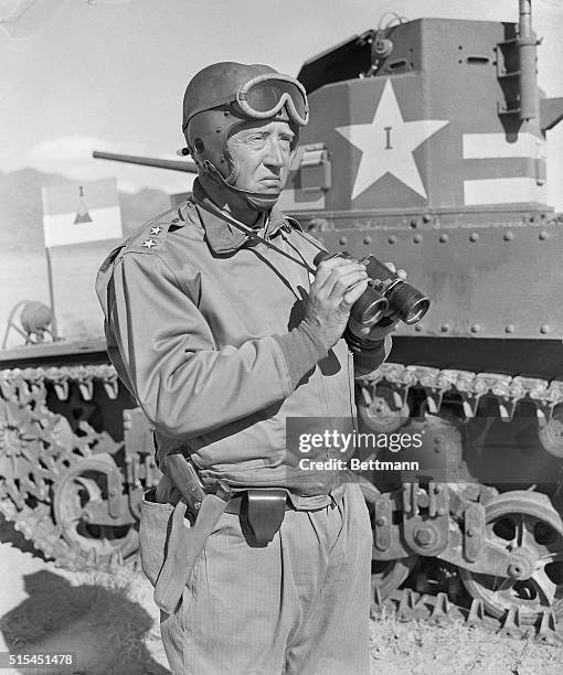 Major General George S. Patton, Jr., commanding officer of First Armored corps, is shown watching, with binoculars, M3 fight tanks on maneuvers. BPA2