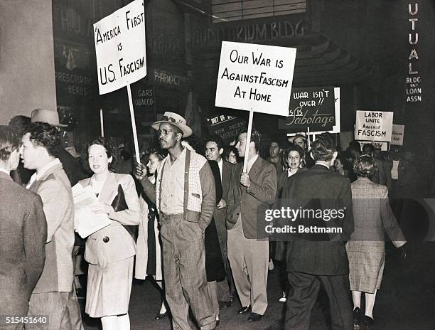 Los Angeles, CA- As Gerald L.K. Smith speaks inside, pickets parade back and forth before this Los Angeles auditorium, carrying placards reading:...