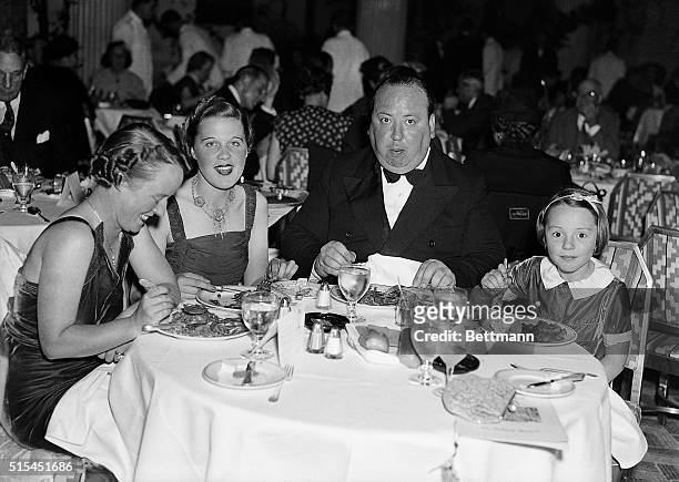 Alfred Hitchcock dining in a New York Restaurant with his wife Alma, his secretary Joan Harrison, and his daughter Patricia.