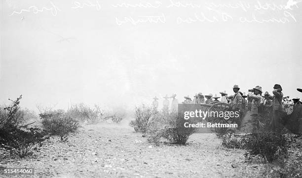 Battle of Juarez, Mexico: Fighting begins with cannon fire from Pancho Villa's troops. Photo shows troops lined up with cannons at the ready.