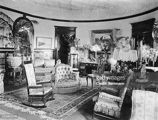 Photo shows an American living room- Victorian. 1890-1900. Undated photograph.