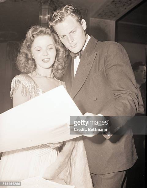 Hollywood, CA-: Seen arriving at a party in Hollywood, Shirley Temple and her good-looking husband, John Agar, inspect a chart of the seating...