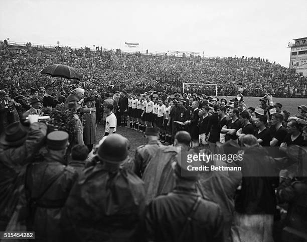 Bern, Switzerland-: Jules Rimet , the elderly and honorary President of FIFA, hands the World Championship Cup to exhausted team captain Fritz Walter...