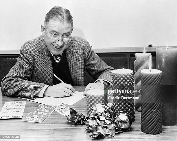 New York, NY- Facing a battery of inspiration by candlelight, humorous poet Ogden Nash prepares to embark on his new career of writing Christmas card...