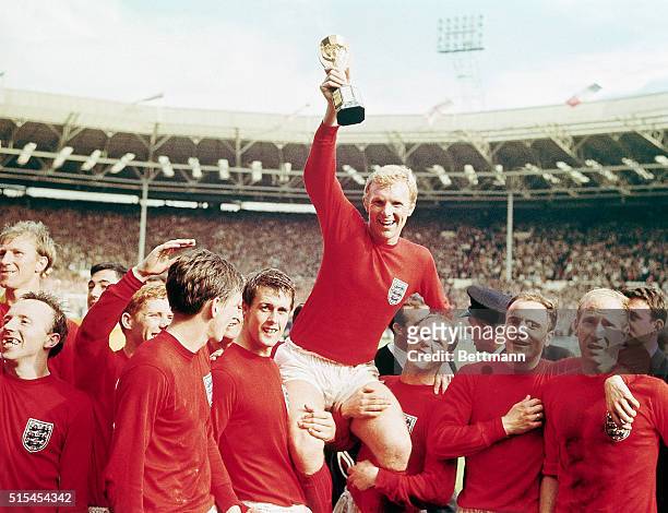 England-: England captain Bobby Moore "chaired" by his team with the Jules Rimet Cup...after receiving it from the Queen after England won the Cup...