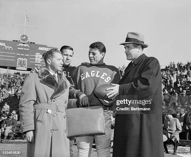 Philadelphia Eagles; end Pete Pihos, , gets a briefcase after handing a symbolic football to Eagle's head coach Jim Trimble before the start of a pro...