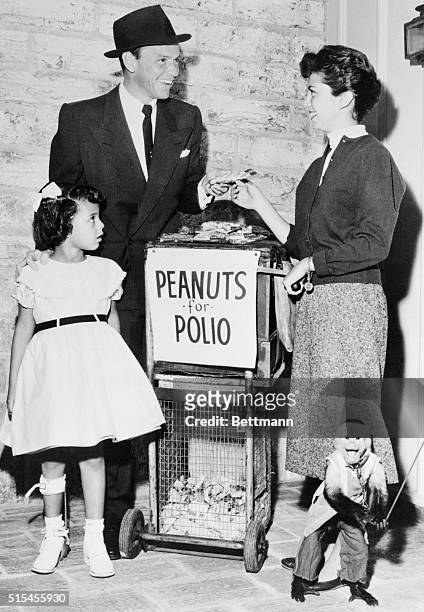 Frank Sinatra buys the first bag of Peanuts for Polio from his 15 year old daughter, Nancy, who represents over a million teenagers selling peanuts...