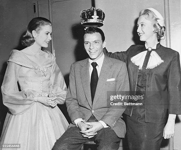 "King" and "Queens". Hollywood: Frank Sinatra is crowned "King of Hearts" by Grace Kelly and Celeste Holm during an impromptu ceremony on the MGM set...