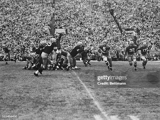 Notre dame Quarterback Paul Hornung starts on a "keeper" play and is stopped by Fred Harris of Iowa for no gain.