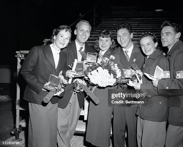 Looking very pleased with their Olympic medals and "Edelweiss" flower bouquets, the Olympic pair figure skating winners smile after the presentation...