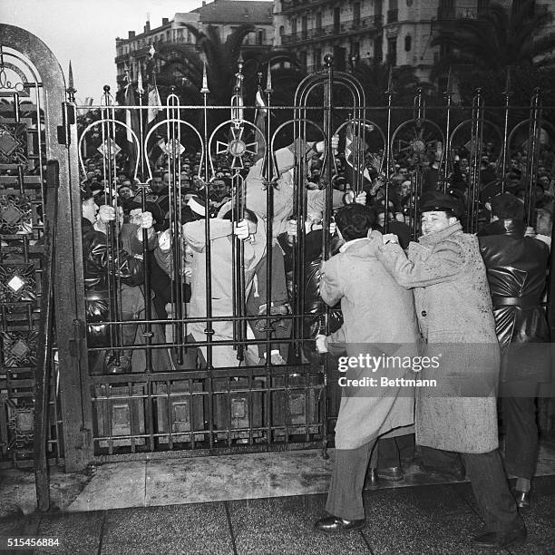 Crowd of demonstrating veterans struggles to open the gate to the Lafarriere Square site of the Algiers War Memorial and scene of recent fighting on...