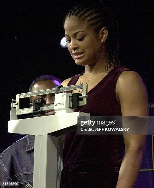 Laila Ali looks down at the scale 07 April 2000 during her weigh-in at a Detroit, Michigan casino in preparation for her 08 April fight against Karen...