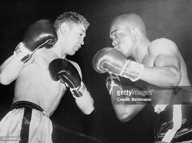 Larry Boardman winds up and throws a right to the world lightweight champion Wallace "Bud" Smith during their 10 round non-title bout at the Boston...