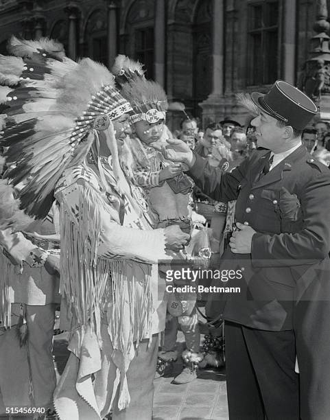 Chief Alone Walker, leader of a troupe of Algonquin Indians from Banff, Canada, stops to have his papoose son admired by a Paris gendarme. The Chief...