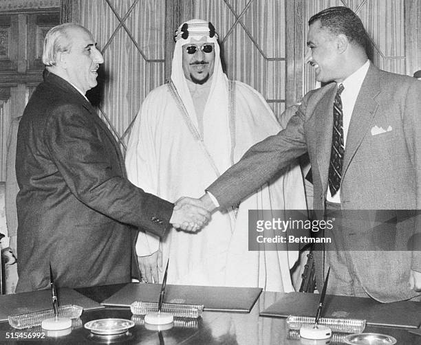 Syrian President Shukry El Kuwatly and Egyptian Premier Gamal Abdel Nasser shake hands, as Saudi Arabia's King Saud looks on smilingly after the...