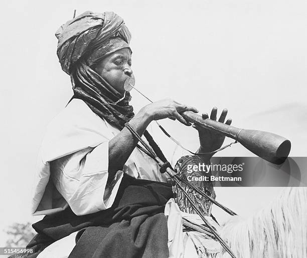 Mounted Nigerian tribesman plays a song of welcome on his alghaita as Queen Elizabeth II and the Duke of Edinburgh arrive at Kaduna in northern...