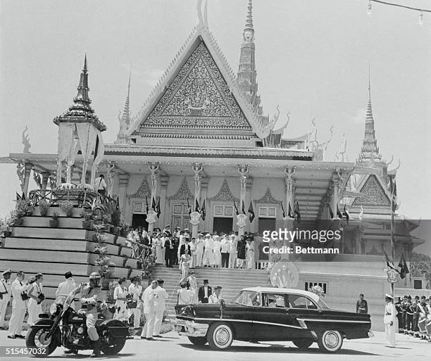 Study in contrast is afforded the camera as a modern U.S. Auto drives up in front of the ornate old Throne Hall in the Cambodian capital of Phnom...