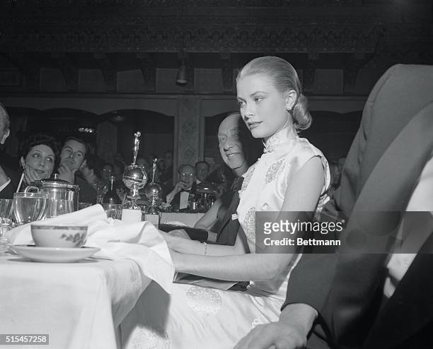 Grace Kelly smiles proudly as all eyes are focused on her and the "Henrietta" award she received here. The award was given to her as "Favorite...
