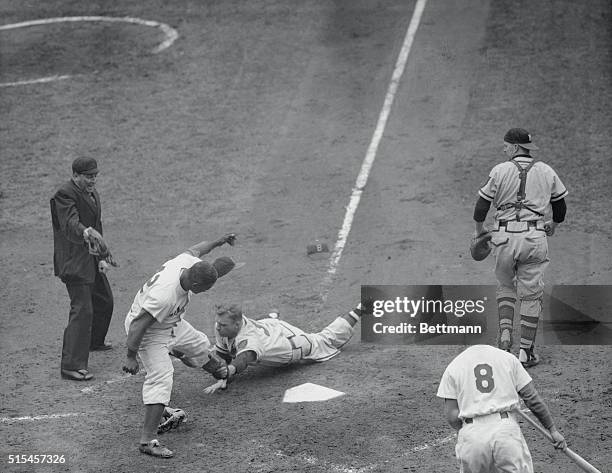 Dodger outfielder Jackie Robinson is shown crossing the plate to score for Brooklyn in the fifth inning of the third world series game at Ebbets...