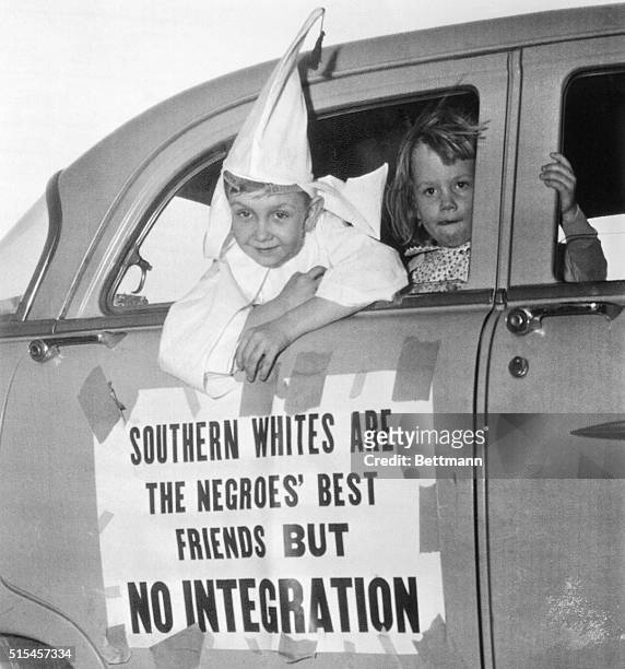 Perry Blevens is all dressed up in his Ku Klux Klansman robes as he rides in the motorcade staged here by the Klan, April 14th. Looking out the car...