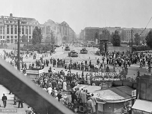 Soviet tanks and machine guns round a turn into Potsdamer Platz to push back crowds of demonstrating workers in East Berlin in the open rebellion...