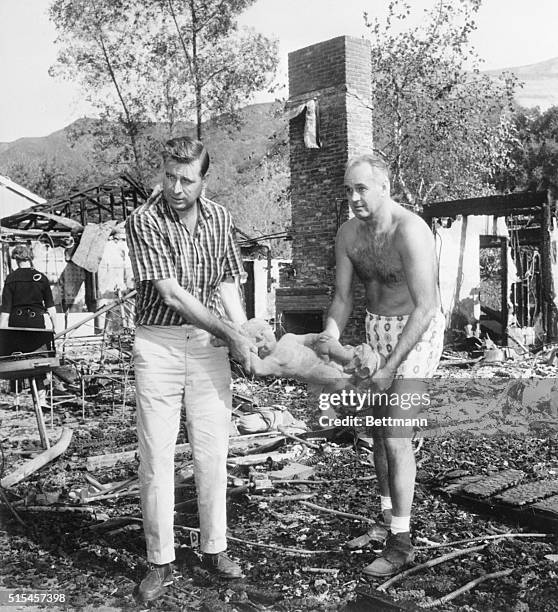 Bel Air, CA- Television writer, Gene Roddenberry and attorney, Frank Swann, remove a statue from the burned-out home of TV producer, Leon Benson. The...