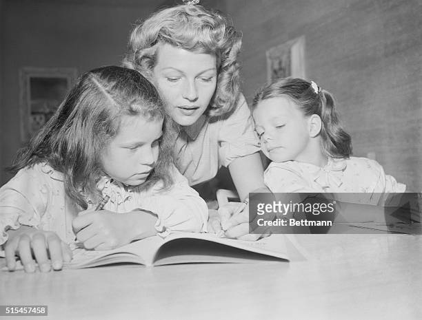 "Rita and Daughters Weild Crayons" Las Vegas, Nevada: Actress Rita Hayworth wields crayon on the coloring book for the benefit of her daughters...