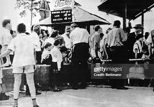 Waiting to Leave. Leopoldville: Carrying their belongings, Belgians line up to board the last ferry leaving for Brazzaville across the river here,...