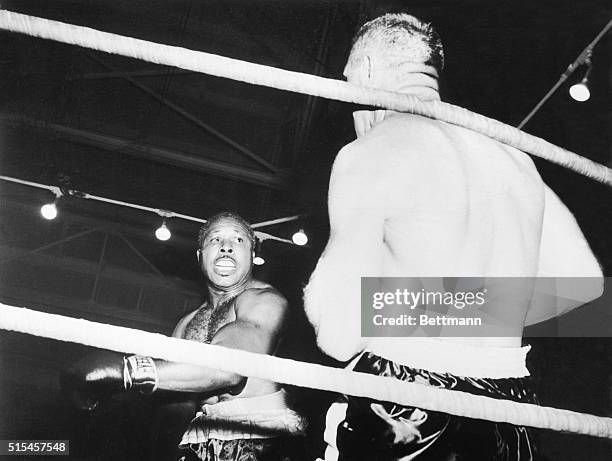 Archie Moore knocks Pete Rademacher into the ropes in the third round of fight here 10/23. This was the blow that cut Rademacher's head. Blood...