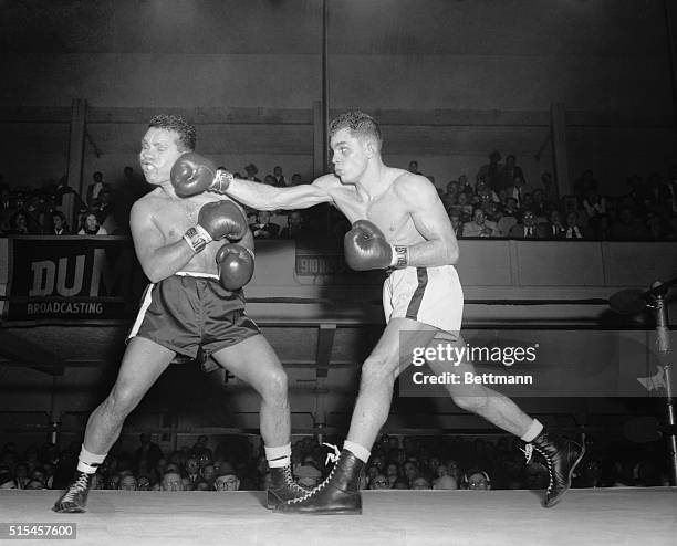 Ray Portilla's face loses its shapely contour as Carlos Ortiz connects with a hard right in the seventh round of their bout at St. Nick's tonight....