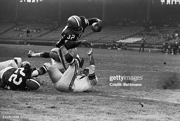 Jim Brown, Cleveland Browns fullback, goes diving over for a touchdown in third quarter on a three yard jaunt. Attempting to stop Brown are Steelers'...