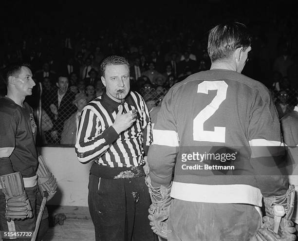 Linesman Doug Davies, bleeding from a cut on his chin, leaves the ice to receive first aid during the Detroit-Montreal Stanley Cup Playoff Game. The...