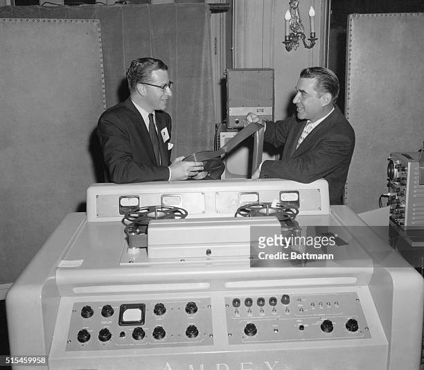 Engineering vice president of CBS-TV William Lodge , and George Long, president of the Ampex Corporation here, view a magnetic tape used to record...
